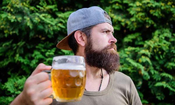 Pracuję aż do oclock piwa. Brodaty człowiek picie piwa na zewnątrz. Hipster korzystających z piwa w lecie. Brutalny człowiek z kubkiem piwa. Drinker relaks z napojem alkoholowym na łonie natury — Zdjęcie stockowe