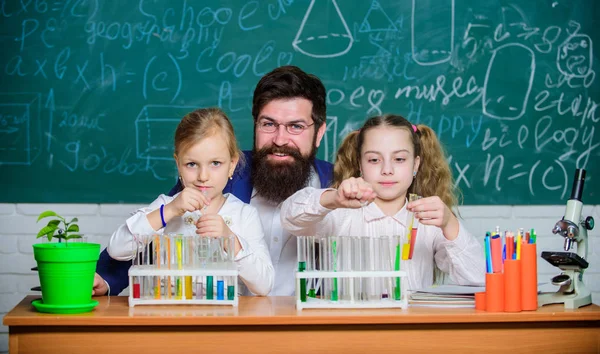 Fascinante lección de biología. El profesor barbudo trabaja con microscopio y tubos de ensayo en el aula de biología. Experimento de biología escolar. Explicar la biología a los niños. Cómo interesar a los niños estudio — Foto de Stock