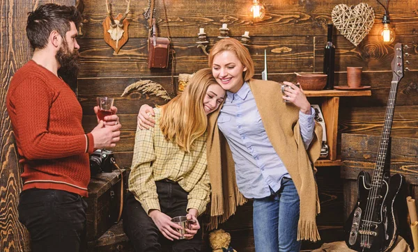 Familie genießt Urlaub im Wildhüterhaus. Gemütlichkeit. Mädchen und Männer mit glücklichen Gesichtern halten metallische Becher in der Hand, genießen die Gemütlichkeit mit Getränken. Freunde, Familie verbringen angenehme Abende, Innenraum Hintergrund — Stockfoto