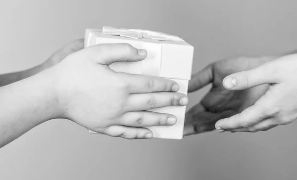 Nothing warms the heart like giving gifts to the people you love. The gift of giving. Childs hands giving a present box to mothers hands. Giving and receiving, keeping it balanced — Stock Photo, Image