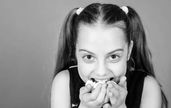 Dente doce incorrigível. Menina sorridente rosto contém doce marshmallows na mão violeta fundo. Conceito dos dentes doces. Miúda com cabelos longos gosta de doces e guloseimas. Calorias e dieta. Miúdo faminto — Fotografia de Stock