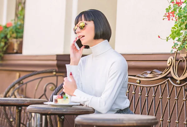 Tempo agradável e lazer. Liga ao amigo. Relaxa e pausa para o café. Menina senhora elegante com smartphone. Conceito de lazer. Mulher atraente elegante morena passar lazer café terraço fundo — Fotografia de Stock