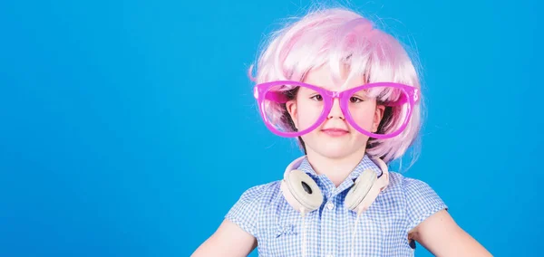 Synthetisch haar. Koele kleine kind met roze haar pruik. Schattig klein meisje met fancy haarstijl dragen hoofdtelefoon. Beauty look van gek haar model, kopieer ruimte — Stockfoto