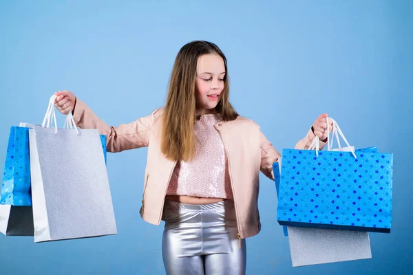 Kledingwinkel. Verkoop en kortingen. Vakantie aankoop opslaan. Klein meisje met boodschappentassen. Kid mode. Shop Assistant met pakket. Gelukkig kind. Klein meisje met geschenken. Kledingwinkel concept — Stockfoto