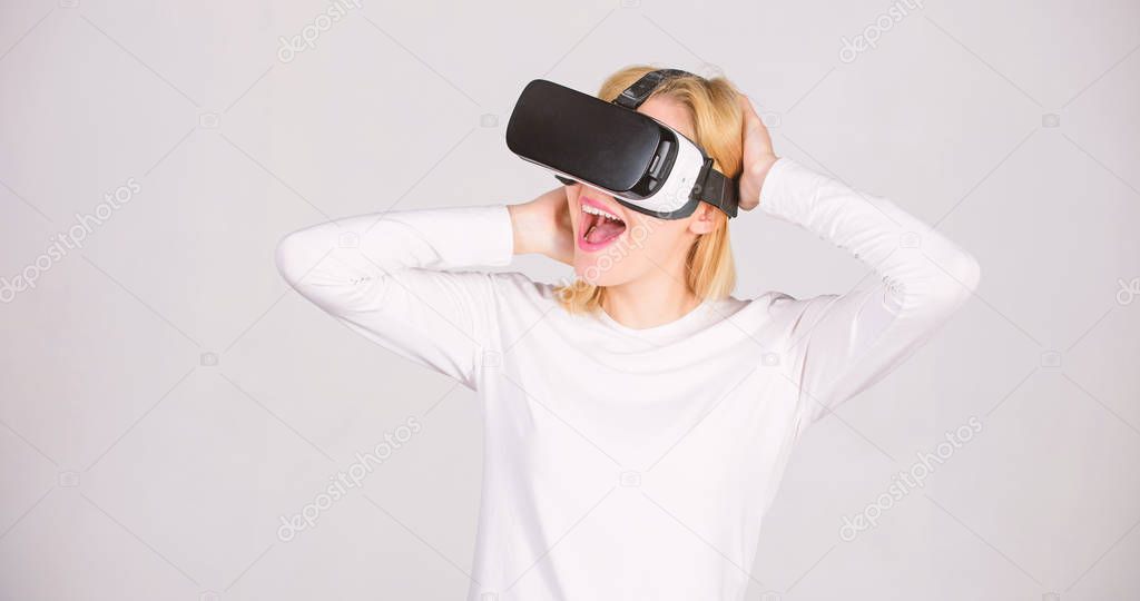 Amazed young woman touching the air during the VR experience. A person in virtual glasses flies in room space. Woman excited using 3d goggles. VR digital.