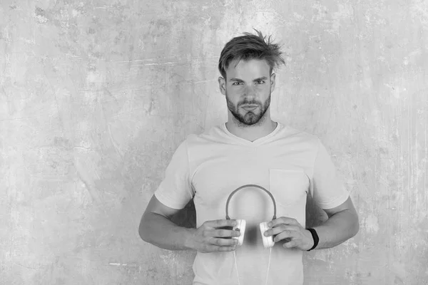 Musikalischer Lebensstil. Blauäugiger stylischer Hipster mit Smartphone. — Stockfoto