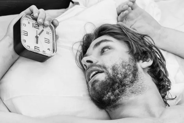 El tipo está acostado en la cama. Un joven despertando en la cama y estirando los brazos. La gente, la hora de dormir y el concepto de descanso - hombre en la cama en casa. —  Fotos de Stock