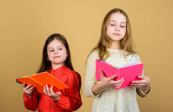 Οι αδελφές κάνουν βιβλία για να διαβάσουν μαζί. Αξιαγάπητα κορίτσια λατρεύουν τα βιβλία. Μυστικό ημερολόγιο. Ανοίγω πόρτες μέσω αλφαβητισμού. Παιδιά με βιβλία ή διαφημιστικά. Εκπαίδευση και παιδική λογοτεχνία. Αγαπημένο παραμύθι — Φωτογραφία Αρχείου