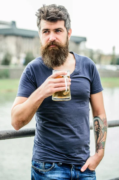 Skäggig man med ölglas utomhus. Slappna av över helgen. En brutal man behöver förfriskningar. dricka alkoholhaltig öl dryck. Gammal hipster med skäggigt hår som dricker öl. Skål för framgång — Stockfoto