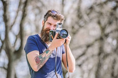 İçerik oluşturucu. Adam sakallı hipster fotoğrafçısı. Sakallı ve bıyıklı fotoğrafçı. Uzun sakallı, fotoğraf çeken adam. Manuel ayarlar. Fotoğrafçı vintage kamera tutun. Modern blogger