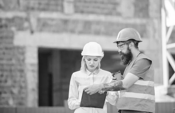 Kvinna ingenjör och builder kommunicera byggarbetsplats. Bygg team kommunikationskoncept. Relationer mellan konstruktion klienter och deltagaren Byggnadsbransch. Diskutera framsteg plan — Stockfoto