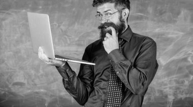 Okul lifehack. Yenilikçi öğretmen giyim gözlük kravat laptop internet'te sörf sahiptir. Öğretmen kurnaz adam modern dizüstü sörf internet kara tahta arka plan sakallı. İlginç bilgiler