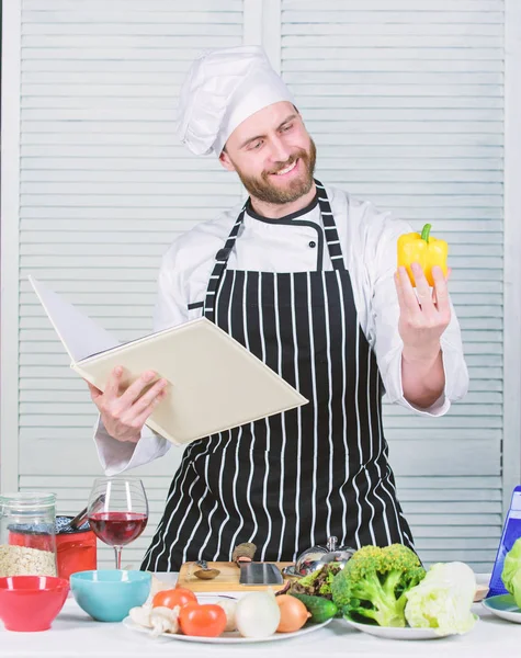 Hombre barbudo cocinero comida. El tipo leyó recetas de libros. Concepto de artes culinarias. Hombre aprender receta. Mejorar la habilidad de cocinar. Guía de cocina definitiva para principiantes. Libro de recetas familiares. Según la receta — Foto de Stock