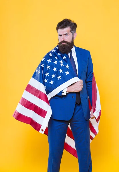 Orgulho nacional. Homem barbudo vestindo bandeira nacional dos EUA em trajes formais. Homem de negócios confiante que celebra férias nacionais no dia 4 de julho. Gerente de negócios nacional em fundo amarelo — Fotografia de Stock