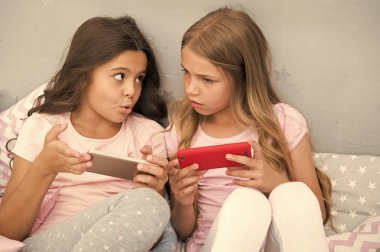 Çocuklar akıllı telefon mobil oyun uygulama oynar. Smartphone uygulama kavramı. Kız gibi boş zaman pijama partisi. Kızlar smartphone küçük blogcular. Sosyal ağ keşfedin. Eğlence için Smartphone