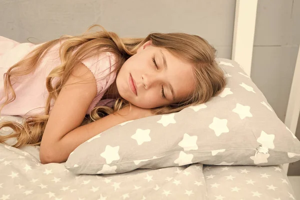 Healthy sleep tips. Girl sleep on little pillow bedclothes background. Kid long curly hair fall asleep pillow close up. Choose proper pillow to relax. Cute pillow and bedclothes for childish bedroom — Stock Photo, Image