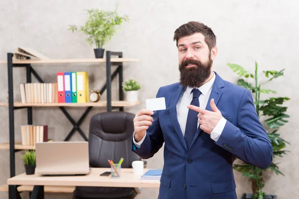 Llámame si tienes alguna pregunta. Diseño de tarjetas. El tipo del traje formal está en la oficina. El hombre de negocios tiene una tarjeta en blanco. Contactos útiles. Barbudo hipster top manager mostrar tarjeta. Servicios bancarios. Abogado privado — Foto de Stock