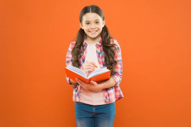 Zihnini genişlet, kitap oku. Turuncu arka plan üzerine küçük çocuk okuma kitabı. Elinde ders defteri olan küçük bir kız. Çocuk için ilginç bir kitap hikayesi