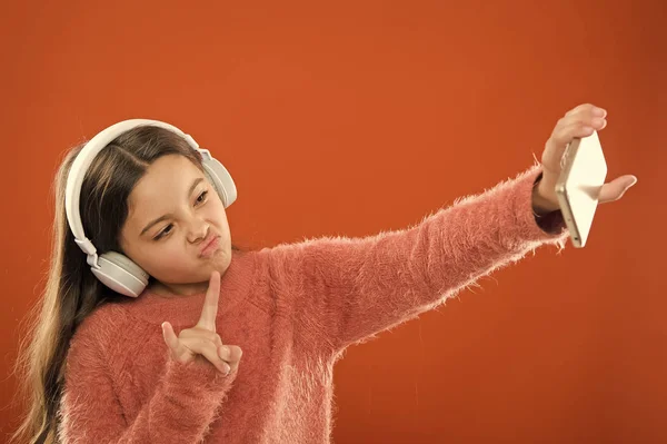 Best music apps that deserve listen. Listen for free. Mobile application for teens. Girl child listen music modern headphones and smartphone taking selfie. Get music subscription. Enjoy music concept