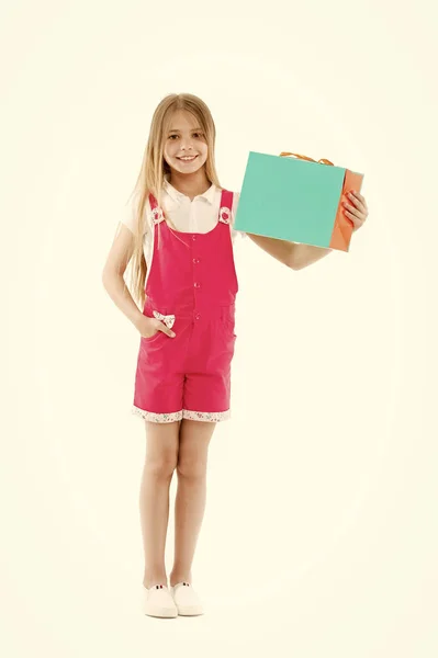 Boldog lány tartsa Papírtáska elszigetelt fehér. Kis shopaholic mosoly a bevásárló táska. Gyermek vásárló papír zsák mosolyogva. Fekete péntek és eladó. Csináltam saját választás, másol hely — Stock Fotó
