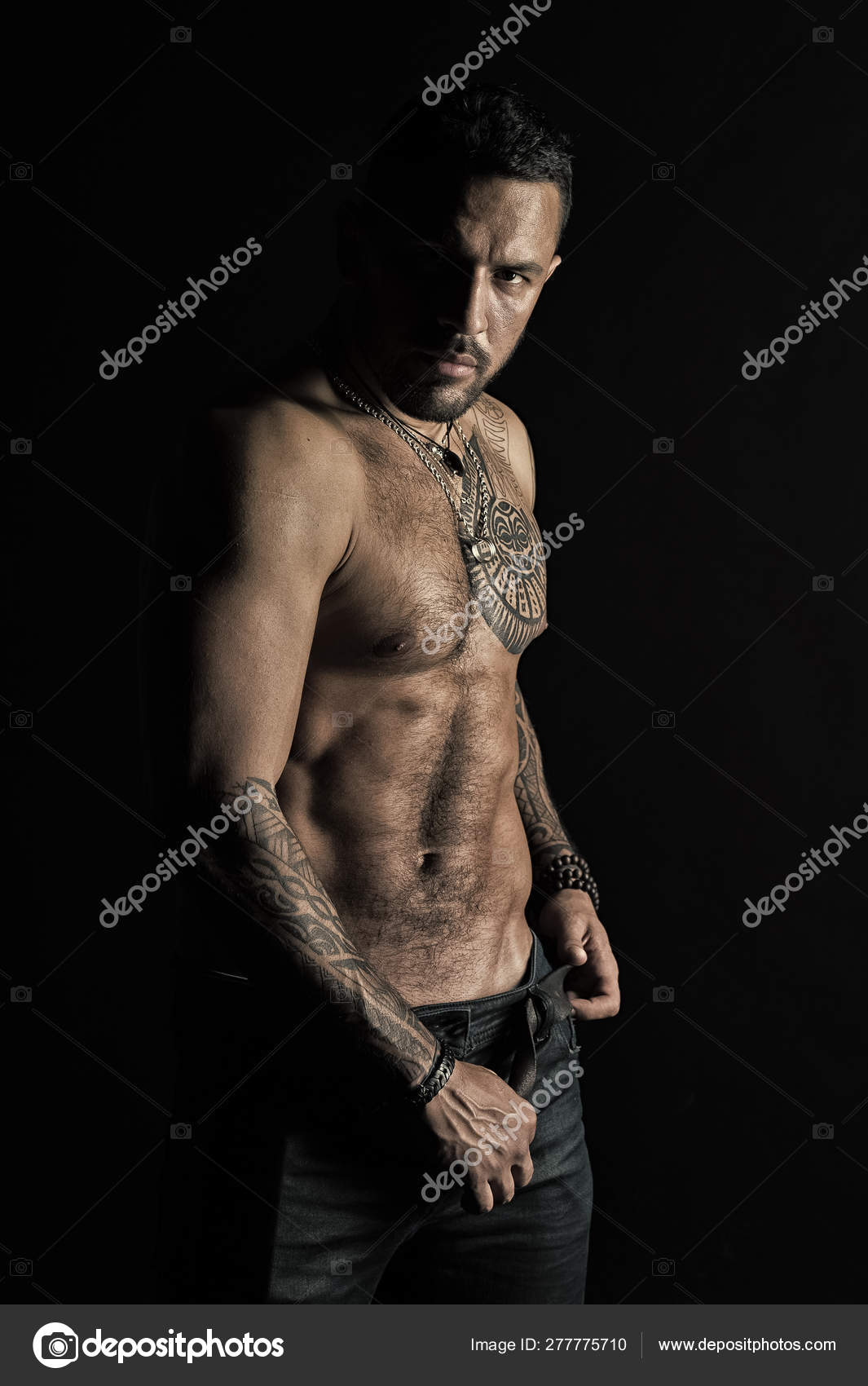 Bearded man shirtless with fit torso. Man with tattoo design on skin.  Fashion model buckle leather