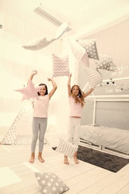 Eğlenmek için akşam vakti. Pijama partisi fikirleri. Kardeşler yatak odası partisinde yastık oyunu oynarlar. Yastık savaşı pijama partisi. Kızlar mutlu en iyi arkadaşlar ya da şirin pijamalı kardeşler Yastıkta pijama partisi