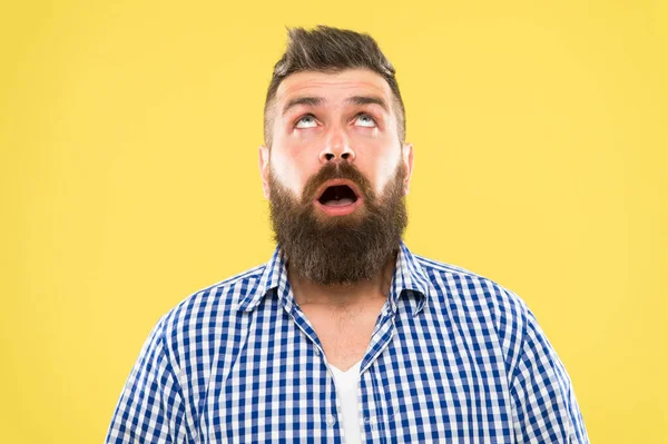 Estilo de vida Hipster. Hipster surpreso com cabelo de barba grossa olhando para cima. Homem hipster brutal mantendo a boca aberta com surpresa no chão amarelo. Homem barbudo em estilo moderno hipster — Fotografia de Stock