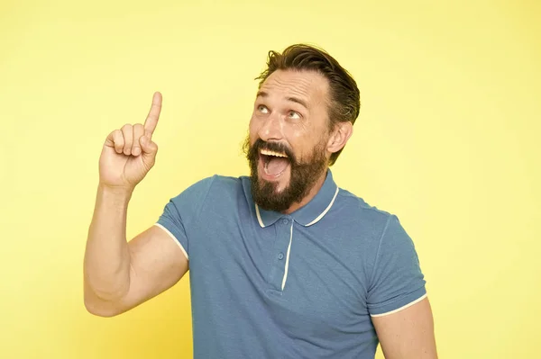 Fresh idea concept. Handsome smiling mature man keeping finger raised and looking upwards while standing against yellow background. Man bearded cheerful fresh idea. Birth of ideas. Idea gesture — Stock Photo, Image