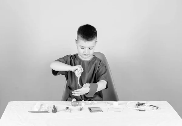 Kid little doctor sit table with stethoscope and medical tools. Medicine concept. Medical examination. Medical education. Play game. Boy cute child future doctor career. Healthy life. Health care — Stock Photo, Image