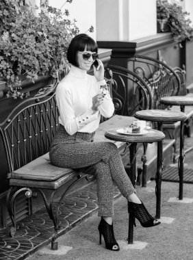 Keyifli zaman ve eğlence. Sakin ol ve kahve molası. Kadın çekici şık esmer eğlence kafe teras arka plan harcamak. Duymak için çok mutluyum. Boş zaman kavramı. Kız moda Bayan smartphone ile