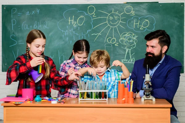 school kids scientist studying science. back to school. happy children teacher. Little kids learning chemistry in school laboratory. students doing science experiments with microscope in lab