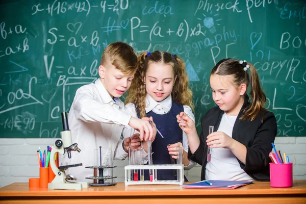 学校の授業で小さな子供たち。小さな子供たちは学校の研究室で化学を学ぶ。化学。学校に戻れ顕微鏡で生物学の実験をしている学生。子供の日。自信のある医師チーム — ストック写真