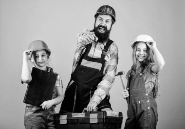 Aile takım çalışması. Onarım. Küçük kızlarla sakallı adam. İnşaat işçisi asistanı. Üretici veya marangoz. Üniformalı tamirci. Mühendisi. Baba ve kız atölyede. Kırma stereotipler