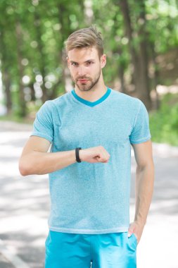 Bilek bandı aleti. Atlet kontrol fitness izci doğa arka plan. Kıllı atlet pedometre gadget ilerleme sonucu bakar. Akıllı saat gadget ile sporcu eğitimi. Modern teknoloji