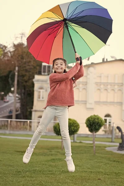 Niña optimista. Accesorio colorido para el humor alegre. Niña alegre niño largo pelo caminando parque con paraguas. Manténgase positivo y optimista. Colorido accesorio influencia positiva. Paraguas brillante — Foto de Stock