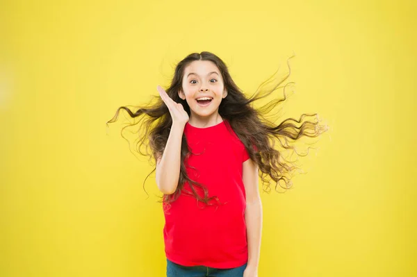 Co za miła niespodzianka. Zaskoczona dziewczyna na żółtym tle. Urocze dziecko z zaskakującymi emocjami na twarzy. Cute little girl utrzymanie usta otwarte duże zaskoczenie. Zadowoleni z zaskoczenia — Zdjęcie stockowe