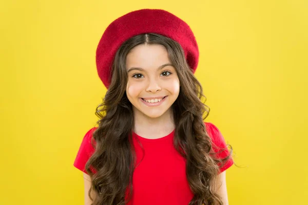 Infância. salão de cabeleireiro. moda de verão e beleza. criança parisiense em fundo amarelo. menina feliz com cabelos longos encaracolados na boina. menina em chapéu de estilo francês. Retrato de moda da menina — Fotografia de Stock