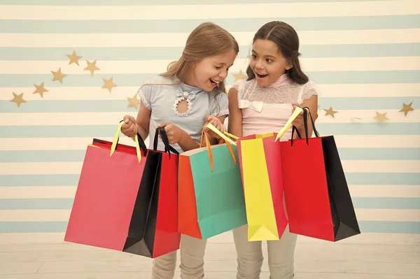 Kedvezmény koncepció. Gyerekek aranyos lány bevásárló táska tartsuk. Vásárlási kedvezmény a szezonban. Időtöltést nagy együtt. Gyermekek elégedett bevásárló csíkos háttér. Megszállottja a vásárlás és plázák ruházat — Stock Fotó