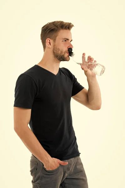 J'ai soif. Homme athlète tenir bouteille d'eau. Il boit de l'eau sur fond blanc. Santé des soins de l'homme et équilibre hydrique. Sportsman soin hydratation eau corps nourrissant. Concept de mode de vie sain — Photo