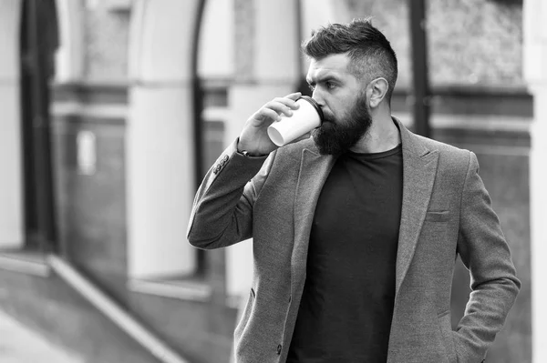 The best time to drink coffee. Bearded man drinking morning coffee. Businessman in hipster style holding takeaway coffee. Hipster with disposable paper cup walking in city. Day begins with coffee — Stock Photo, Image