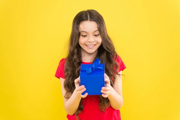 Oavsett hur gammal du blir närvarande är alltid kul. Happy Kid får presentera på boxnings dagen. Liten flicka leende med insvept presentbox. Litet barn som håller födelsedagspresent på gul bakgrund — Stockfoto