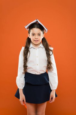 Bir ton okuyun, öğrenmek eğlencelidir. Komik küçük çocuk turuncu arka plan üzerinde kafasına okumak için kitap tutan. Okulda okumayı öğrenen sevimli küçük kız. Başarılı olmak için okuyun
