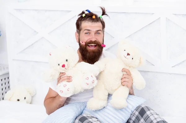 Slumber party. Guy relaxing in bedroom. Pajamas style. Man in pajamas at home. Having fun pajamas party. Childlike again. Man adult bearded handsome hipster with childish hairstyle colorful ponytails