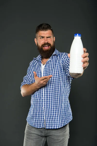 Gesunde Trinkgewohnheiten. fröhlicher Hipster, der auf die Flasche zeigt, um natürliche Milch zu trinken. bärtiger Mann, der Milchprodukte trinkt. Milch trinken für eine bessere Verdauung — Stockfoto