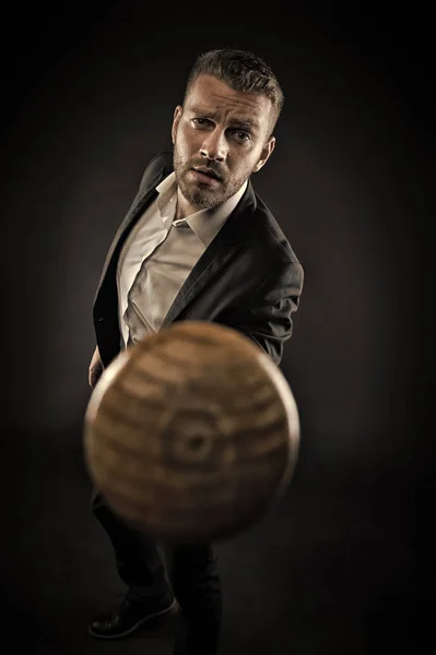 Bearded man pointing baseball bat. Man in smart suit threatening with wooden bat. Aggressive business style, ambitions concept. Businessman isolated on black background. Manager with outraged look