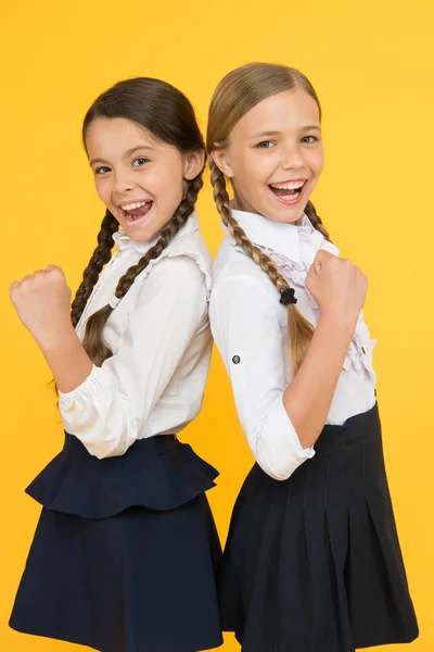 Prémio dos melhores alunos. Excelentes pupilas. Meninas roupa uniforme perfeito no fundo amarelo. Fazendo tudo certo. Segundo as regras da escola. Colegas de turma alunos arrumados. Programa educacional para crianças talentosas — Fotografia de Stock