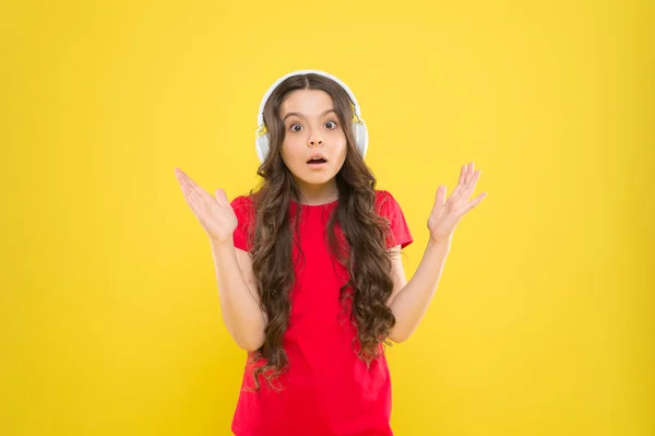 Hören und leben. entzückender Headset-Benutzer auf gelbem Hintergrund. kleines Kind mit verstellbarem weißem Headset. kleines Mädchen mit drahtlosem Headset. Nettes Kind hört Musik im Stereo-Headset — Stockfoto