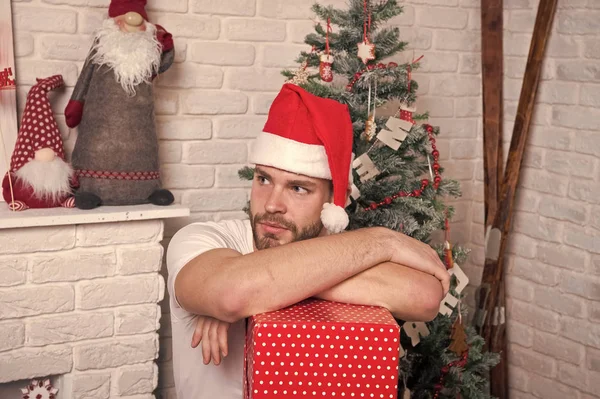 Entrega regalos de Navidad. compras de Navidad en línea. Escena de año nuevo con árbol y regalos. hombre en sombrero de santa celebrar regalo de Navidad. La mañana antes de Navidad. Feliz hombre santo. Feliz Navidad. Te extraño. — Foto de Stock