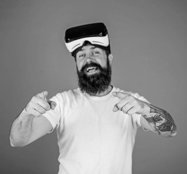 Sakal ve bıyık Vr gözlük, mavi arka plan ile olan adam. VR teknolojisi kavramı. Adam Vr gözlük veya baş ile ekran monte. Hipster ileri işaret parmağı ile işaret mutlu yüz