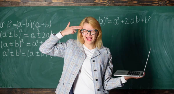 Oktató okos okos hölgy modern laptop tartsa pisztoly gesztus a fejét Chalkboard háttérben. Fáradt tanár bosszantotta a munkáját. Nő fáradt vagy bosszús tart laptop. Az oktatásreform koncepciója — Stock Fotó